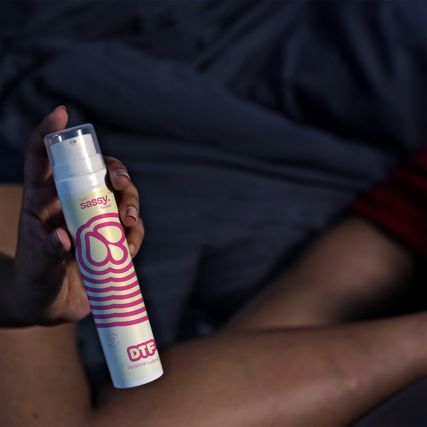 DTF All Natural Water-Based Personal Lubrication Gel Held In Hand While In Bed.