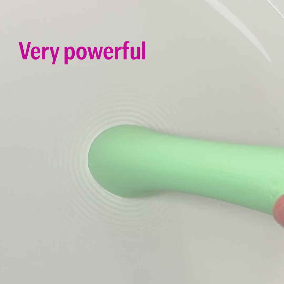 OG massager for women in green showing powerful vibration ripples in water.