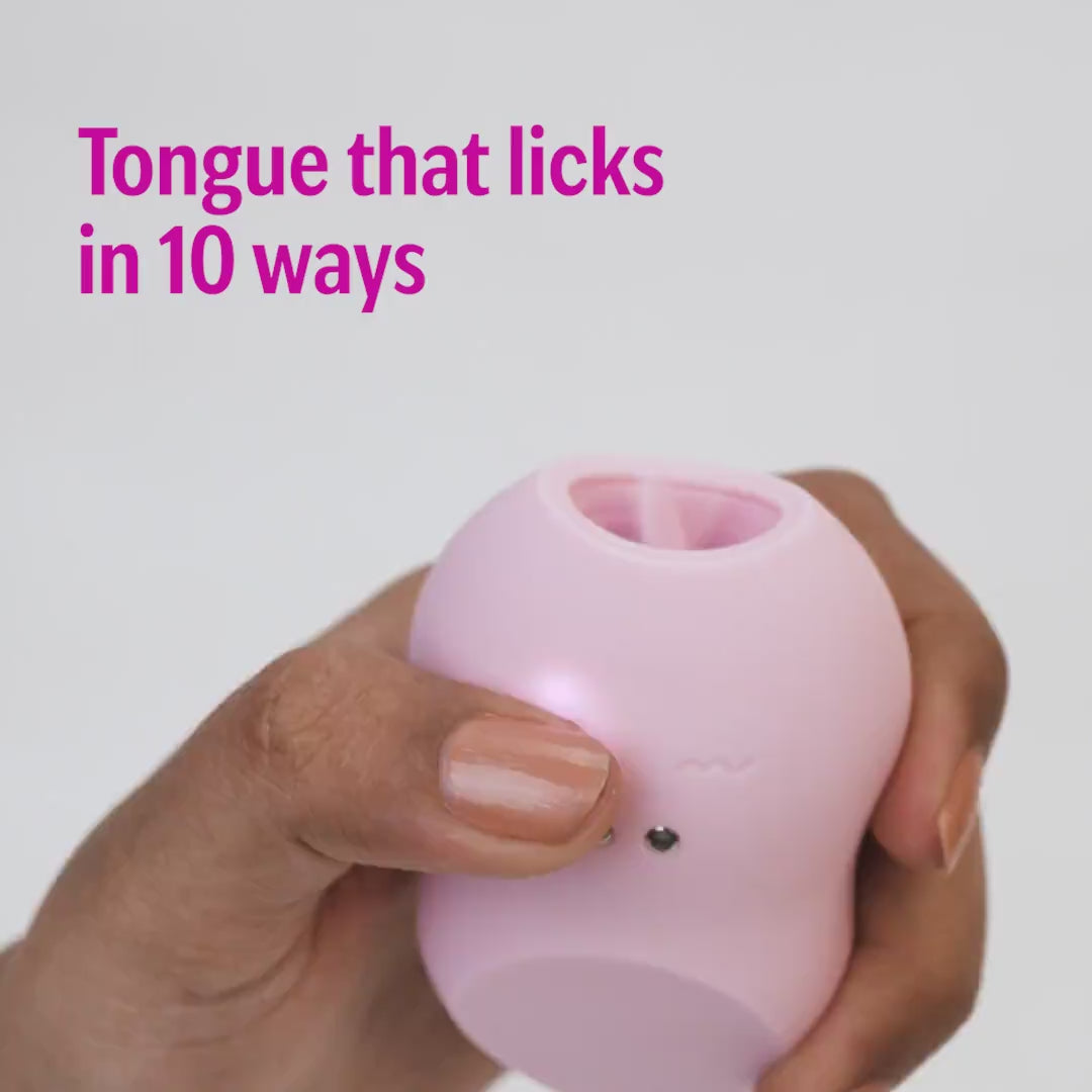 Pink tongue massager with 10 licking modes held in hand
