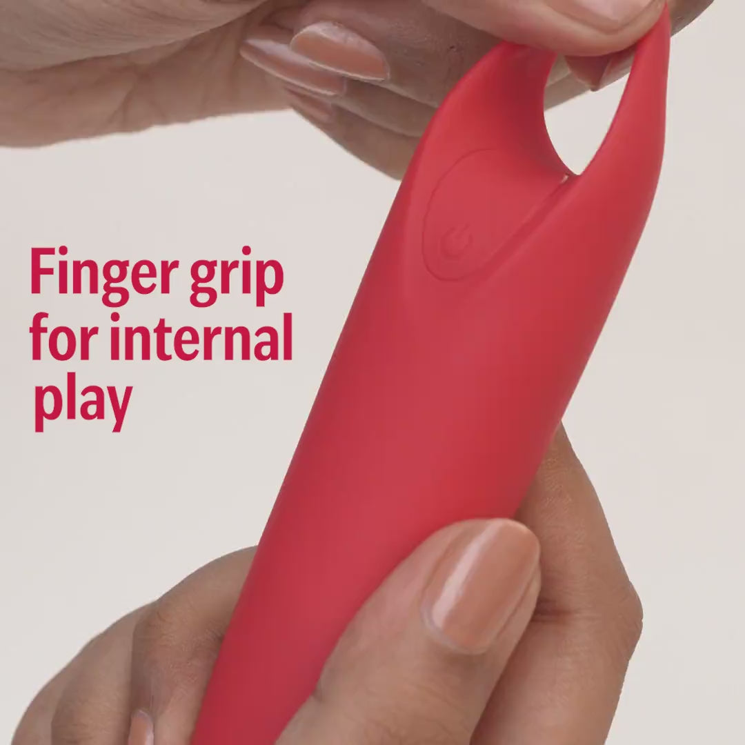 Close-up of hand holding red Candy handheld massager with finger grip for internal use.