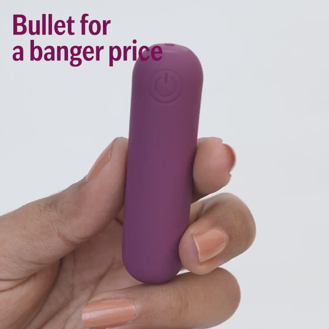 Plum bullet massager held in hand close-up