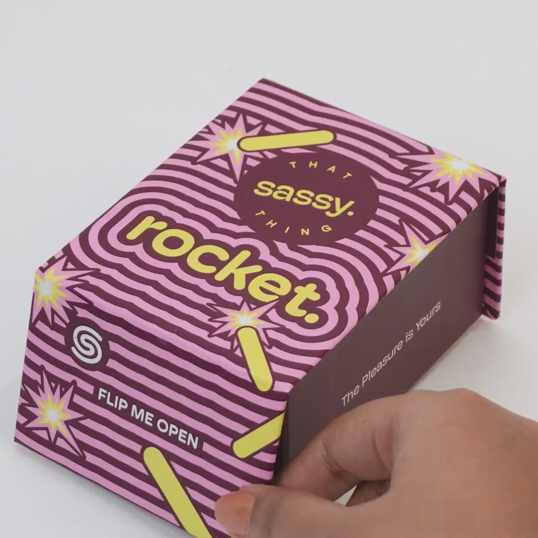 Hand holding bullet massager with product packaging