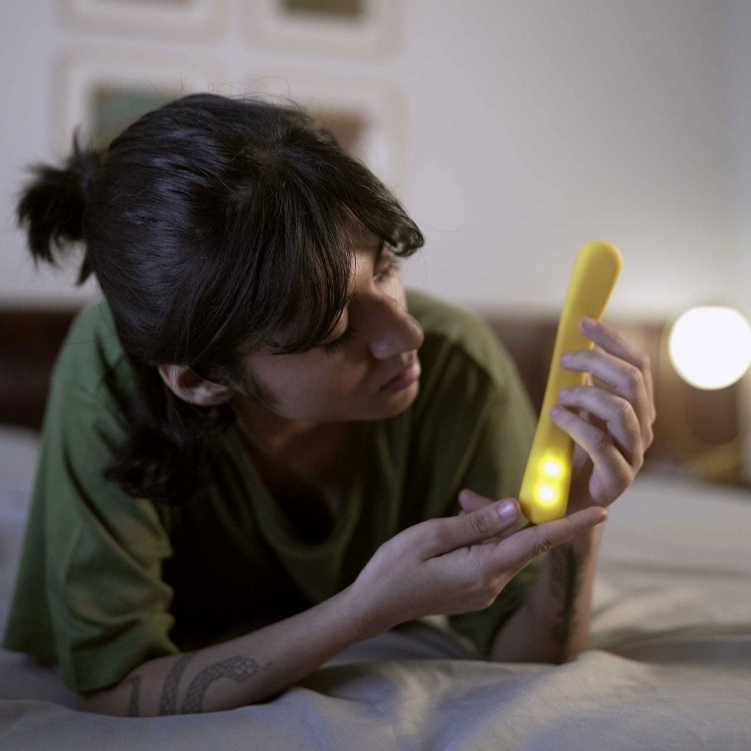 woman examining yellow colored flex internal massager