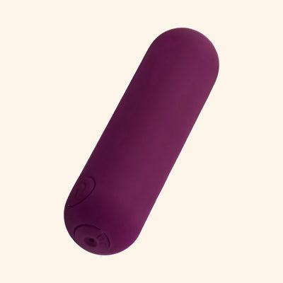 Plum bullet massager on plain background