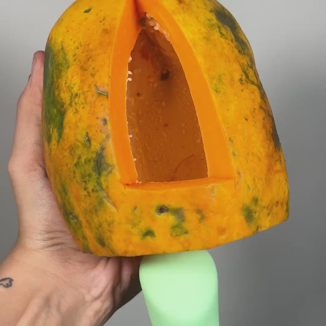 OG personal body massager for women shown inside papaya for demonstration.